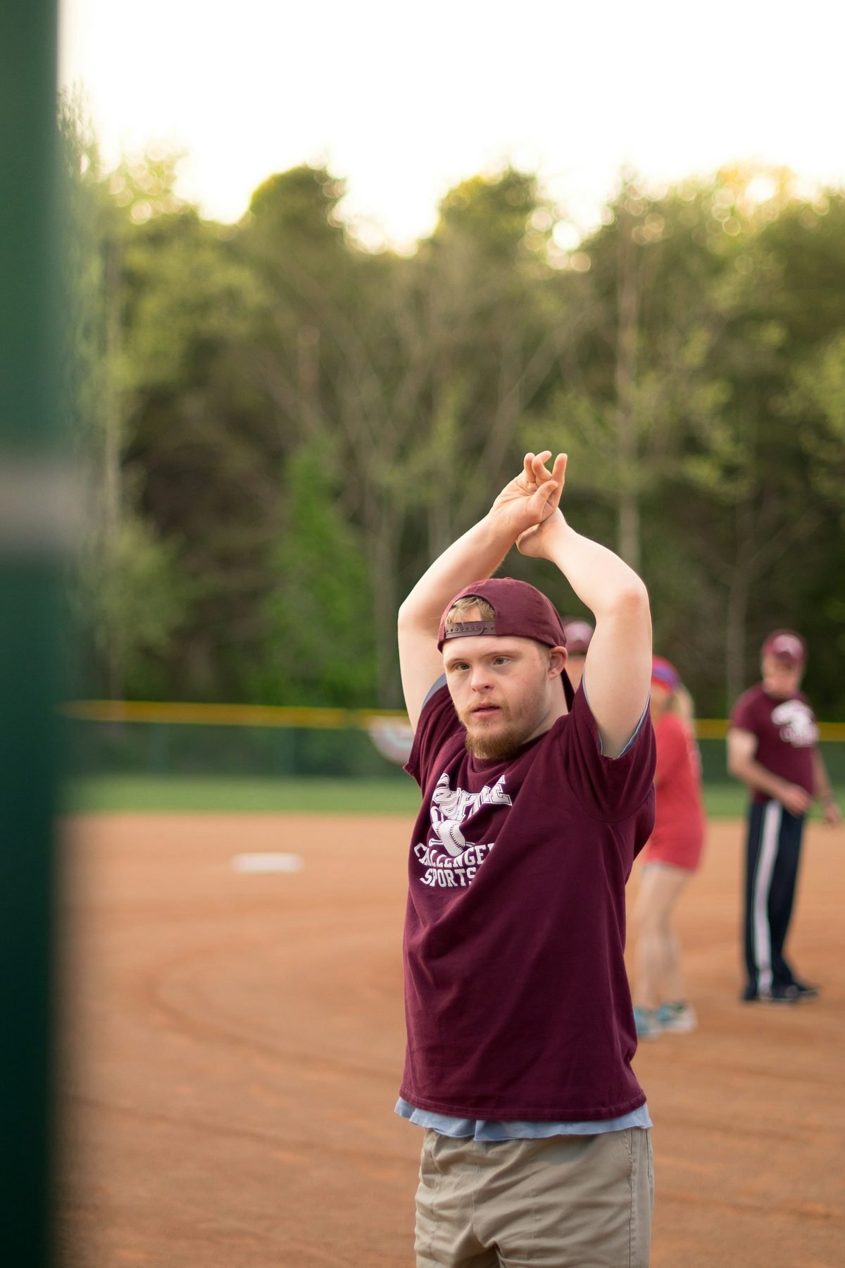 A young man celebrating with his arms raised on a ball field